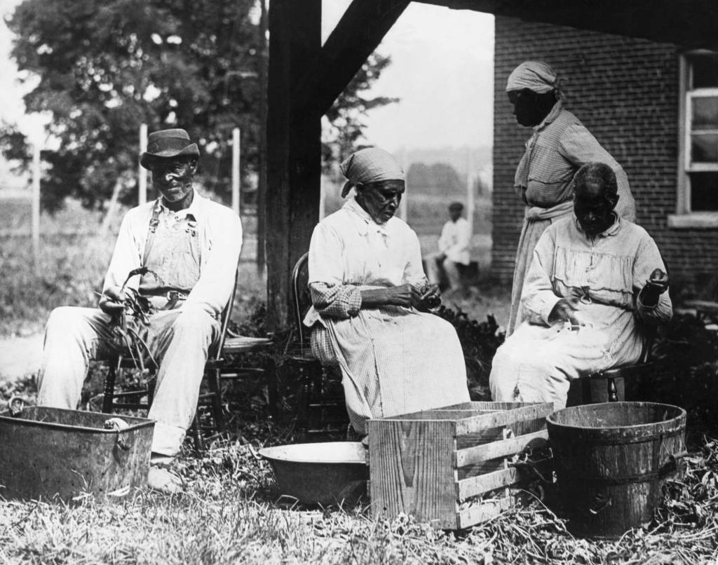 A photograph of a group of formerly enslaved people at a country almshouse, circa 1900.  Photo-Bettman Archive/Getty Images