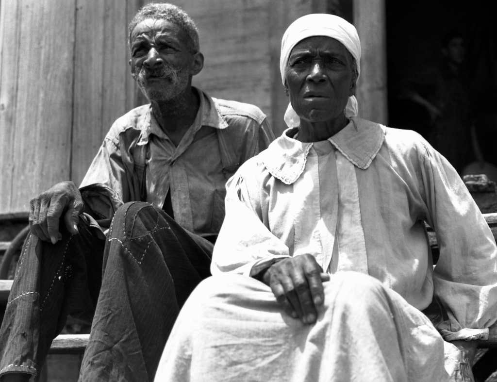 A former enslaved man and woman are shown at a plantation house in Greene County, Georgia, circa 1937. -Photo: Corbis/Getty images